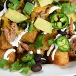 pulled pork totchos recipe in a white bowl and ready to eat