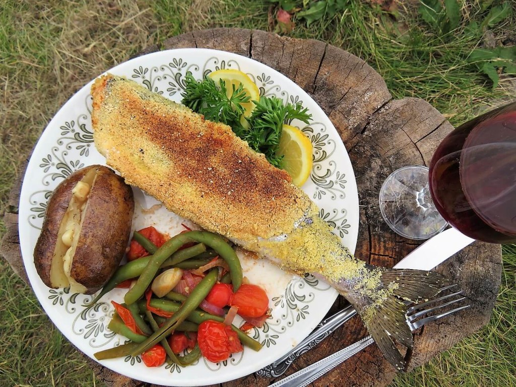 corn crusted trout on a campfire skillet