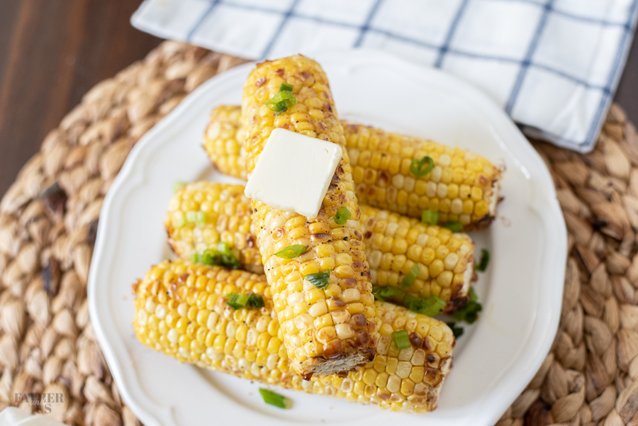 Corn on the cob cooked in air fryer with a pat of butter melting on top.